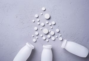 Different pills and tablets on grey background