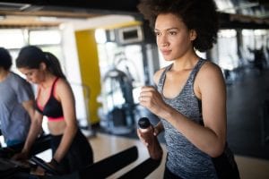 Young woman running on a treadmill in health club